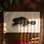 Canvas flag with a beaver design on a wooden surface